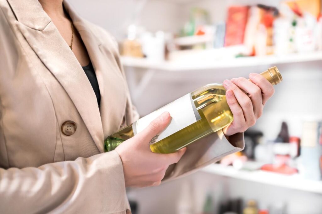 a woman holds a bottle of wine