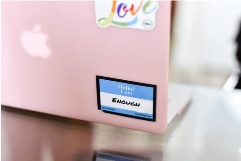 pink laptop has sticker on it that says i am enough for national recovery month