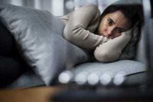 woman curls up on the couch and needs a depression treatment center
