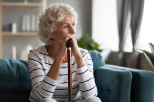 older woman sitting on couch wondering aobut Triggers Of An Anxiety Attack