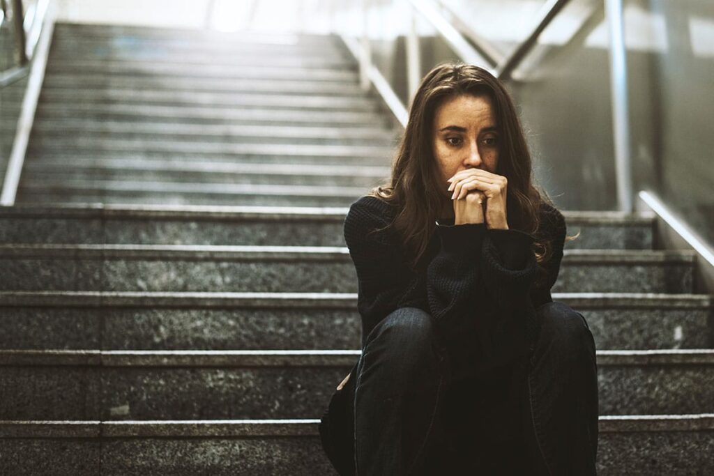 Person sitting on outdoor steps, thinking about how many non fatal overdoses there are in York County