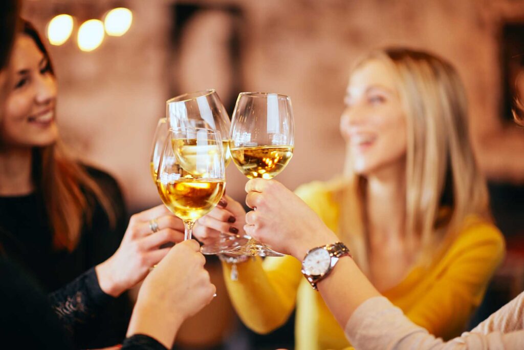 Women drinking wine and not considering the link between consuming alcohol and breast cancer risk