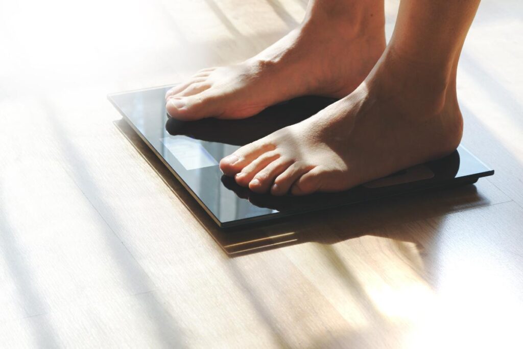 Feet of person wondering what causes weight gain after quitting alcohol